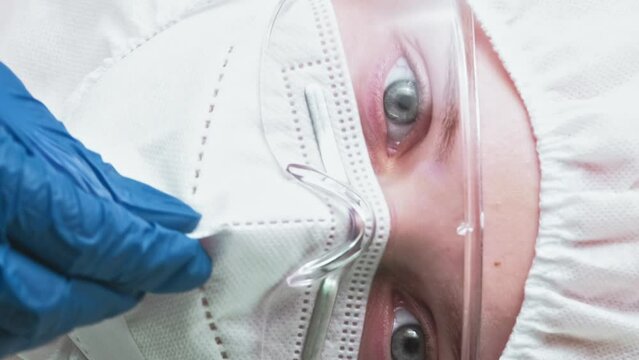 Vertical video. Air contamination. Ecological disaster. Respiratory protection. Woman scientist in blue gloves white face mask goggles equipment.