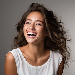 portrait of a beautiful young latin model woman laughing and smiling with clean teeth