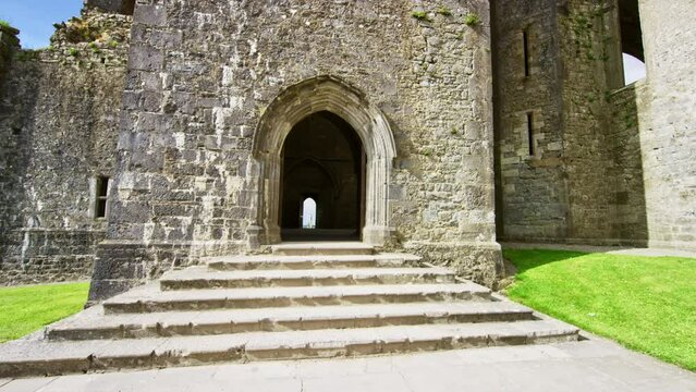 Camera floating pushing in towards abbey. Rock of Cashel Ireland