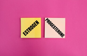 olored paper with the words estrogen and progesterone. concept of female hormones and menopause