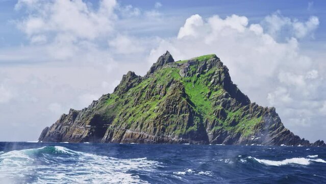 Skellig Micahel in distance with waves crashing and boat exaust.