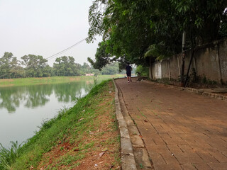 pedestrians in the evening, as a means of exercise to stay healthy, the beautiful lake Gintung is beautiful for sports tourism.
