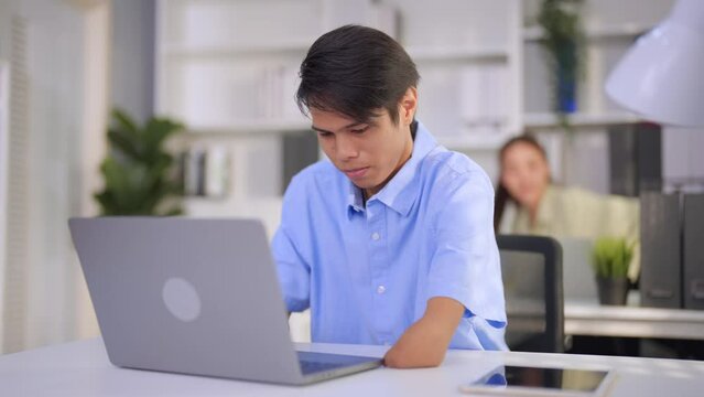 Asian young businessman amputee without arm working on table in office.