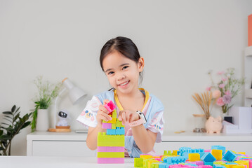 little girl is happy Playing colorful block puzzles. in the white room