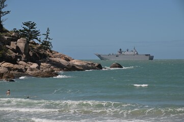 Tourists looking at HMAS Adelaide Australian landing helicopter dock ship passing by Magnetic...
