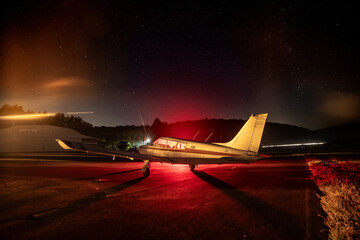 Private plane on airport parking ramp at night with sky full of stars - 644294357