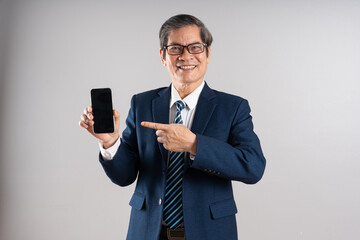 Portrait of an elderly Asian businessman, posing on a blue background