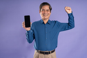 portrait of middle aged asian business man posing on purple background