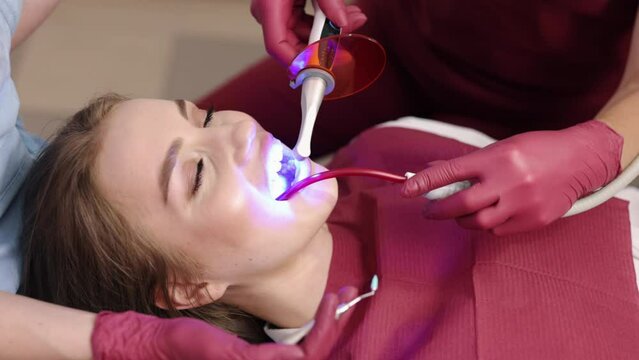 Patient teeth, Patient procedure, Teeth light. As part of patient's dental treatment and restoration, stomatologist shines UV light on photopolymer in dental clinic.