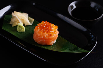 Salmon Sushi roll with caviar topping Japanese food isolated in black background