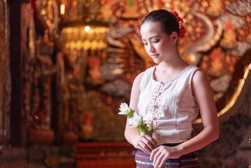 A Thai young girl dressed in traditional costumes visits a Sridonmoon temple in Chiang Mai,...