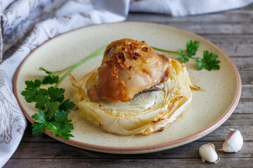 Baked chicken drumsticks with cabbage washers and garlic on plate. Closeup. Horizontal format