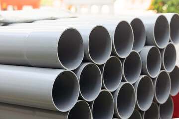 on the construction site, awaiting installation. These durable and lightweight pipes are organized neatly, with their varying sizes and lengths strategically placed next to each other. 