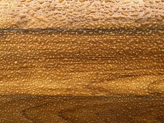 Water drops on the golden teak belt background