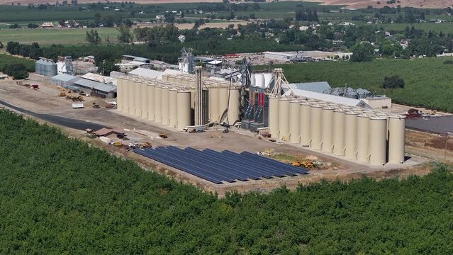 Aerial Sutter California rice elevator solar panels 1. Economy based on farming rice, grains, walnuts peaches and cattle ranch. Fields act as wetlands for waterfowl and birds.