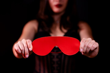 Close-up of a girl in lingerie with a red blindfold. Black isolated background. Sex toys, Sex shop. Girl in sexy lingerie © Granmedia