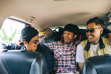 Three best male friends travel together. Sitting in a backseat car and having fun. Summer adventure concept.