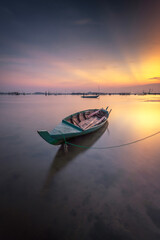 Fishing boat in the water at sunset. Beautiful sunset over the sea - 644323743