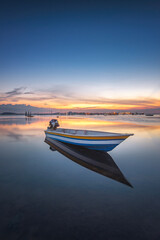 Fishing boat in the water at sunset. Beautiful sunset over the sea - 644323786