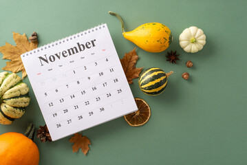 Elevate your autumn-themed content with this top view snapshot. Ripe pumpkins, calendar and traditional fall attributes laid out on a green backdrop, providing space for text or advertisements
