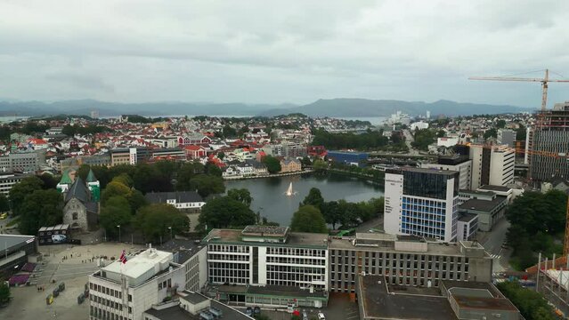 Aerial dolly toward Breiavatnet lake with fountain in Stavanger city, Norway