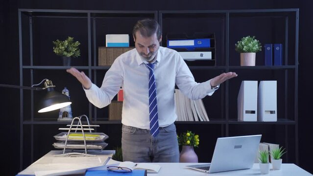 Angry businessman messing up standing desk in office.
