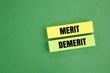 colored paper with the words Merit and Demerit. fine concept. Merits refer to the advantages. Demerits refer to the unfavorable points of something