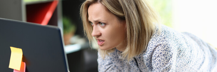 Confused and upset woman looking at computer screen