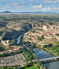 Fototapeta na wymiar Aerial image of the eastern part of the old town of Toledo in which you can see the Alcazar, the Alcantara Bridge crossed by the Tagus River and the Castle of San Servando in detail