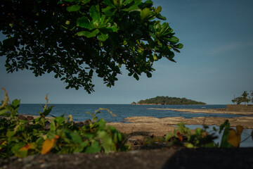 Isla Uvita viewed from the city of Limon in Costarica on a sunny day. Visible beach in Limon on sunny afternoon and small island in the background.