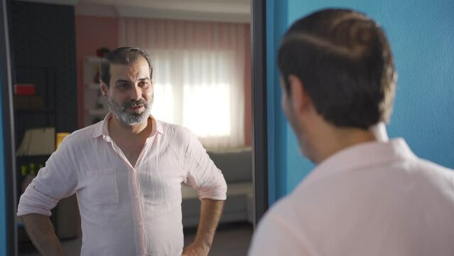 Man talking to himself looking in the mirror.