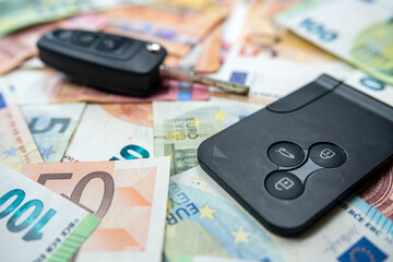 Black car key on euro bills banknotes, finance concept