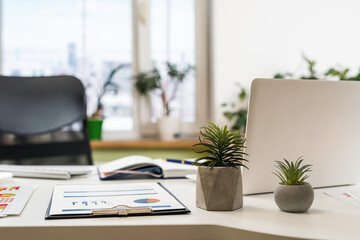 Home workspace with laptop books, pen colour pencils and supplies