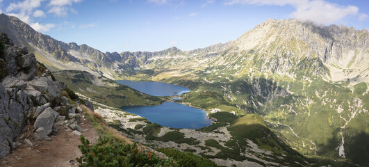 Beautiful alpine valley with mountain peaks, lakes, and some vegetation, panoramic, Poland, Europe