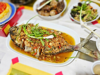 Thai Tradition Food: deep-fried fish topped with fresh herbs and soybean paste sauce on plate. Asian cuisine food