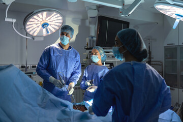 Three surgeons doing laparoscopic surgery. Doctors looking at image on monitor. Medicine and healthcare concept. Internal organ of patient seen on computer monitor