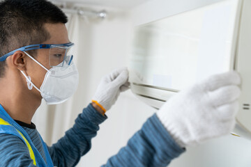 Fototapeta premium Professional male staff cleaning, air conditioning, inspection and maintenance for good hygiene and reduce electricity bills.