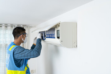 Professional male staff cleaning, air conditioning, inspection and maintenance for good hygiene and...