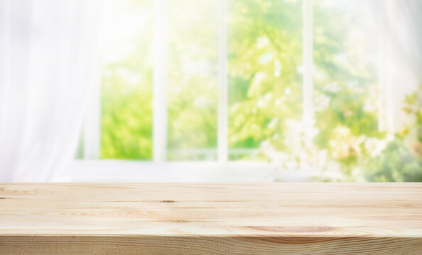 Fototapeta selective focus.Empty of wood table top on blur of curtain window and abstract green from garden with sunlight .For montage product display or design visual layout