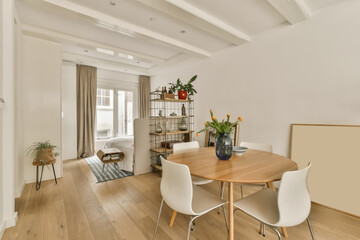 a dining room with white walls and wood flooring there is a wooden table in front of the wall,...