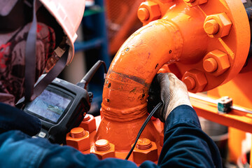 Non-destructive testing technicians are checking the thickness of elbow tubes using ultrasound (UT) testing methods, ultrasound testing to determine the residual thickness after use.