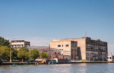 Photo of a building undergoing renovation with a serene body of water in the foreground Danube Delta birds wild life