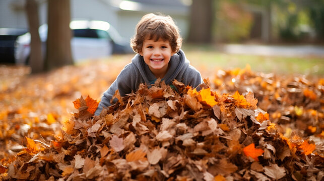 A child playing in a pile of raked leaves.
