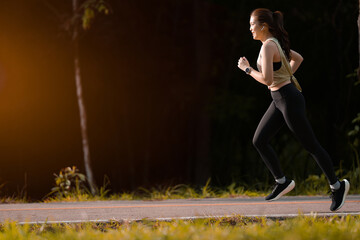 Asian woman wearing sportwear jogging exercise in the park.