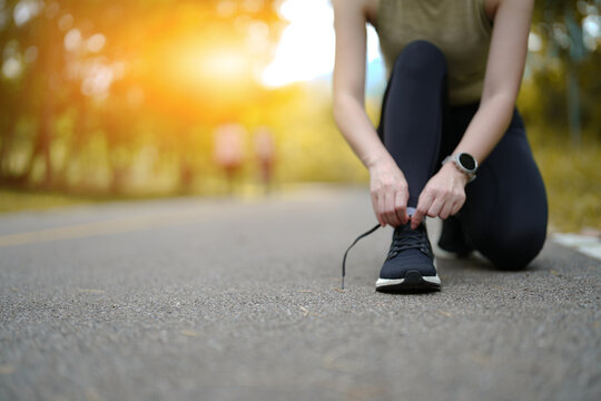 Close up front view of young asian woman tying shoelace
