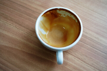 Close up empty coffee cups with stains left in the cups on the wooden table in the cafe.