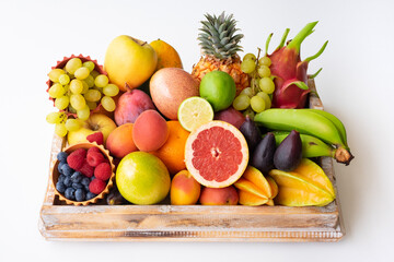 Top view of basket full of mixed ripe colorful fruit. Tropical, seasonal, healthy eating concept