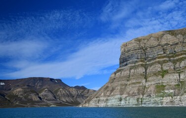 Naklejka premium the heavily striated skansen cliffs in the billefjorden on a boat tour on a sunny day near longyearbyen, svalbard, norway 