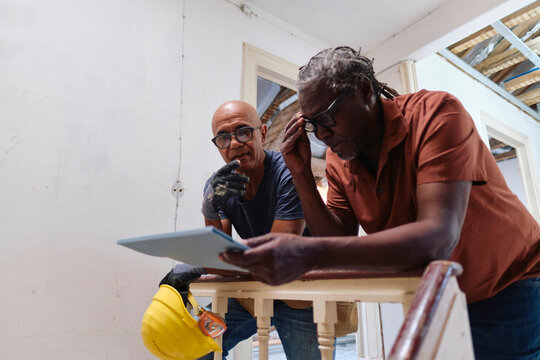Architect and builder having discussion together over document