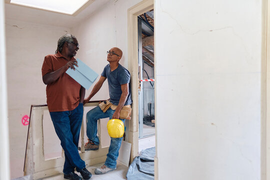 Architect and builder having discussion at site